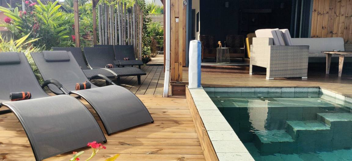 Transats alignés sur le deck en bois au bord de la piscine