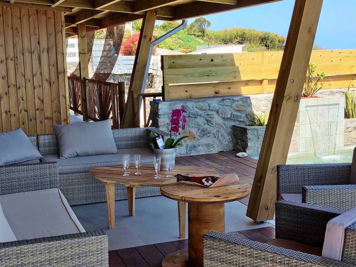 Espace lounge couvert avec champagne, orchidée et cascade de pierre
