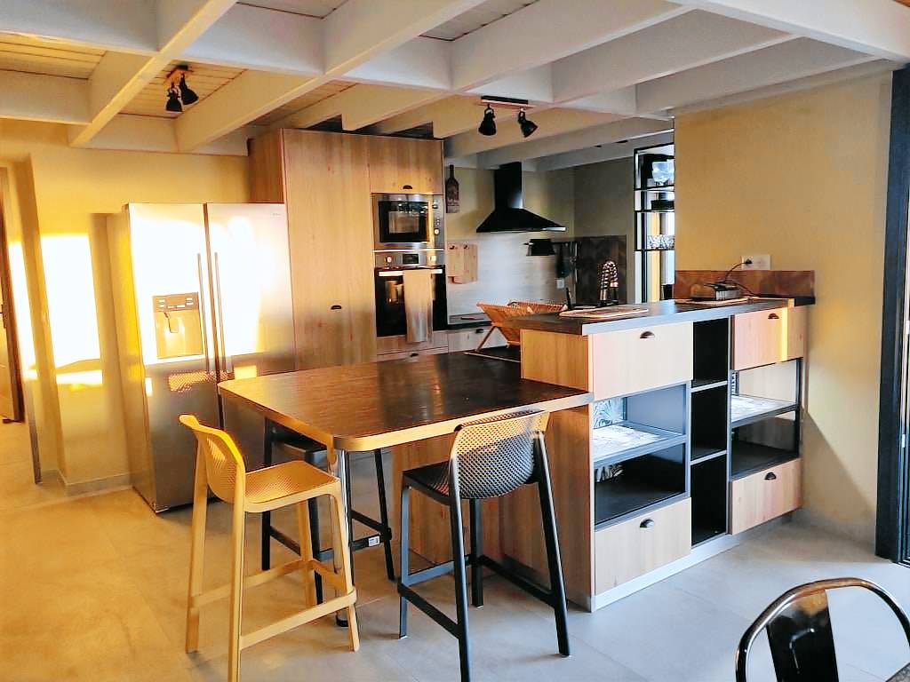 Cuisine américaine entièrement équipée avec îlot et tabourets