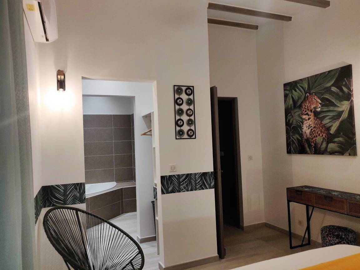 Chambre avec salle d'eau attenante, climatisation et décor jungle
