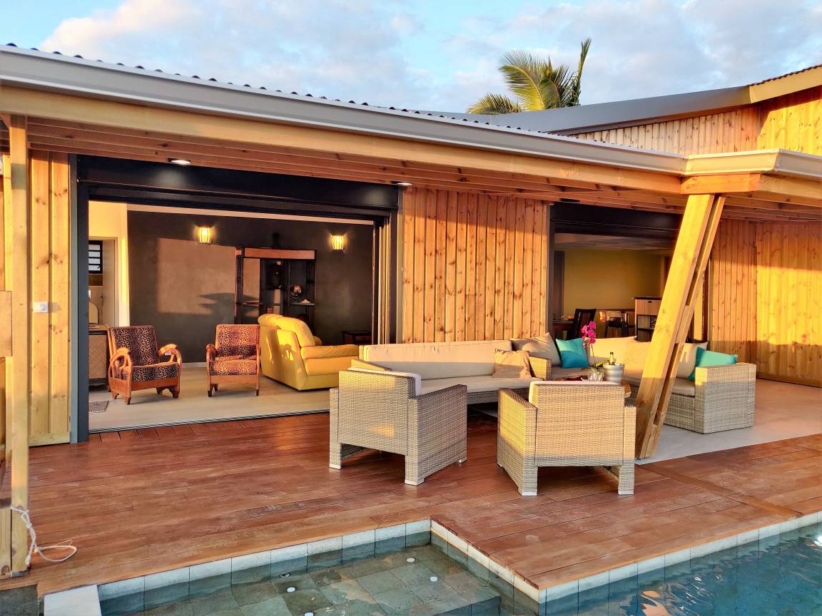 Deck en bois et salon extérieur en résine tressée au coucher du soleil